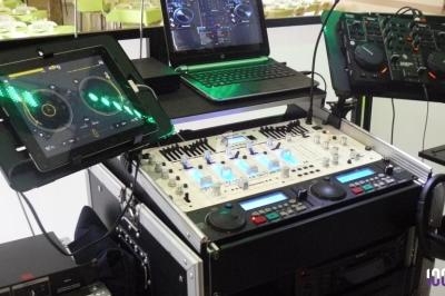 Équipement de DJ comprenant une table de mixage, des platines, un ordinateur portable et des tablettes tactiles.