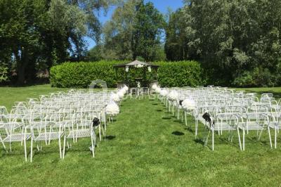Vue d'un étang entouré d'arbres et de végétation sous un ciel partiellement nuageux.