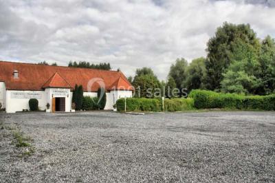Vue d'un étang entouré d'arbres et de végétation sous un ciel partiellement nuageux.
