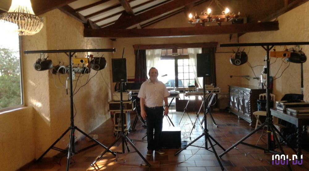 Un homme se tient au centre d'une salle équipée de matériel de sonorisation et d'éclairage.