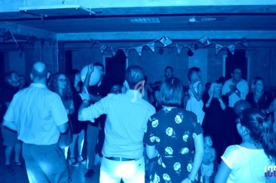 Groupe de personnes dans une salle décorée, participant à une fête ou un événement convivial.