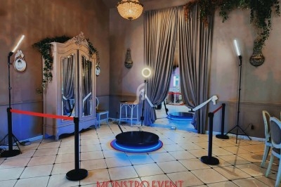 Plateforme photo interactive entourée de lampes et de rideaux dans une pièce élégante avec un décor raffiné.