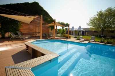 Un artiste sur échasses interagit avec une femme dans un espace intérieur éclairé, avec des spectateurs en arrière-plan.