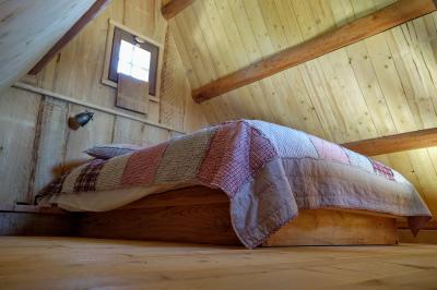 Un artiste sur échasses interagit avec une femme dans un espace intérieur éclairé, avec des spectateurs en arrière-plan.