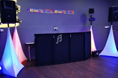 Installation de matériel de sonorisation et d'éclairage dans une salle décorée pour un anniversaire de 18 ans.