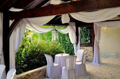 Terrain de sport en plein air avec pelouse et piste en terre, entouré de maisons et d'arbres sous un ciel dégagé.