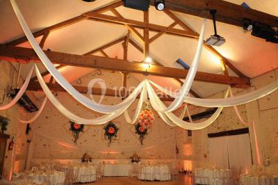 Terrain de sport en plein air avec pelouse et piste en terre, entouré de maisons et d'arbres sous un ciel dégagé.