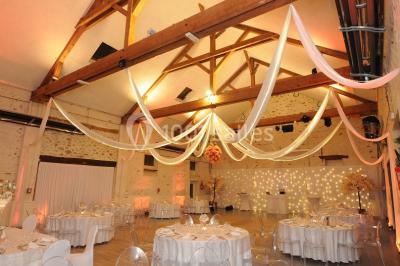 Terrain de sport en plein air avec pelouse et piste en terre, entouré de maisons et d'arbres sous un ciel dégagé.