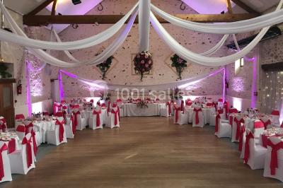 Terrain de sport en plein air avec pelouse et piste en terre, entouré de maisons et d'arbres sous un ciel dégagé.