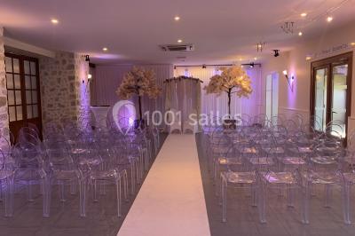 Terrain de sport en plein air avec pelouse et piste en terre, entouré de maisons et d'arbres sous un ciel dégagé.