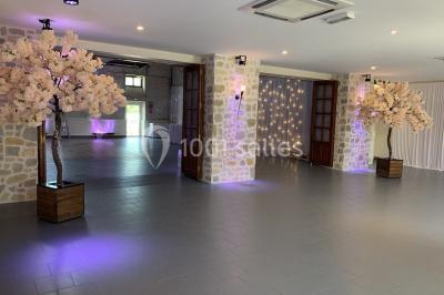 Terrain de sport en plein air avec pelouse et piste en terre, entouré de maisons et d'arbres sous un ciel dégagé.