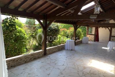 Terrain de sport en plein air avec pelouse et piste en terre, entouré de maisons et d'arbres sous un ciel dégagé.