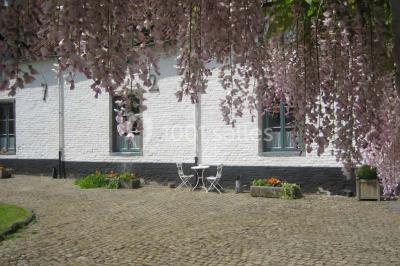 Miniature Location salle Court-Saint-Étienne (Brabant wallon) - Ferme de Beaurieux #5 Charpente en bois apparente d'un bâtiment ancien avec des murs en briques et un éclairage intérieur chaleureux.