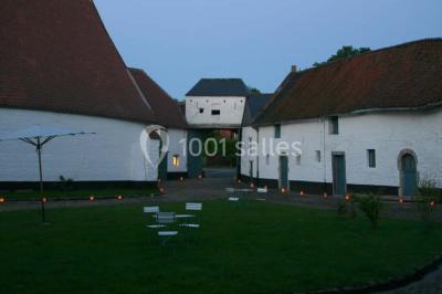 Miniature Location salle Court-Saint-Étienne (Brabant wallon) - Ferme de Beaurieux #8 Charpente en bois apparente d'un bâtiment ancien avec des murs en briques et un éclairage intérieur chaleureux.