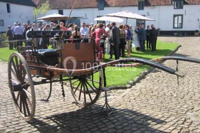 Miniature Location salle Court-Saint-Étienne (Brabant wallon) - Ferme de Beaurieux #11 Charpente en bois apparente d'un bâtiment ancien avec des murs en briques et un éclairage intérieur chaleureux.
