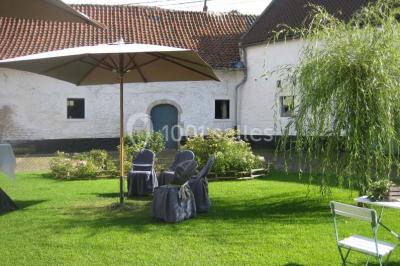 Miniature Location salle Court-Saint-Étienne (Brabant wallon) - Ferme de Beaurieux #15 Charpente en bois apparente d'un bâtiment ancien avec des murs en briques et un éclairage intérieur chaleureux.