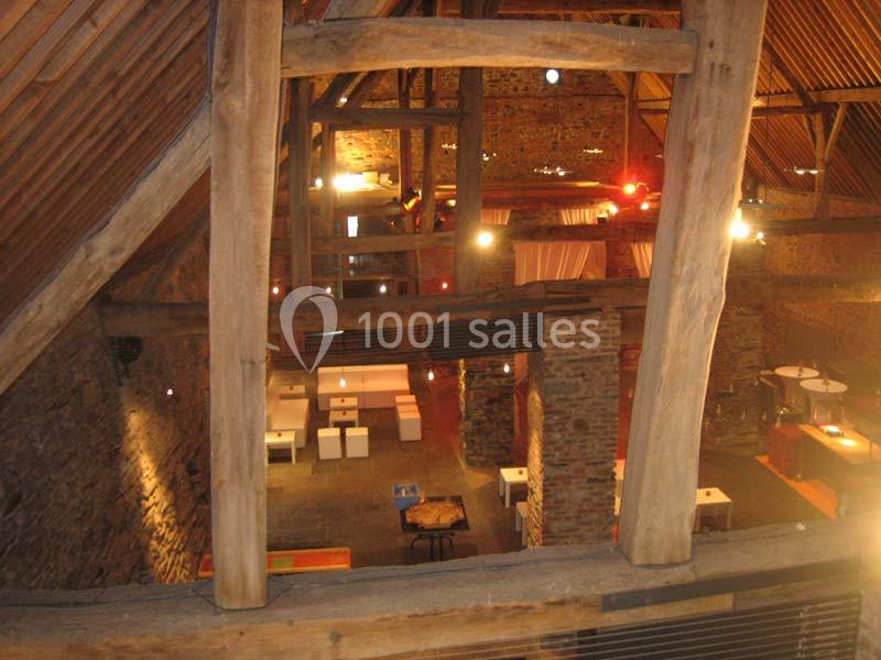 Location salle Court-Saint-Étienne (Brabant wallon) - Ferme de Beaurieux #16 Vue intérieure d'une grange rénovée avec des murs en pierre, des poutres en bois et un aménagement lumineux moderne.