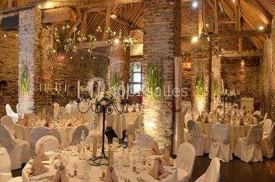 Paysage hivernal avec arbres dénudés, sol enneigé, clôture en bois et maisons en arrière-plan sous un ciel gris.