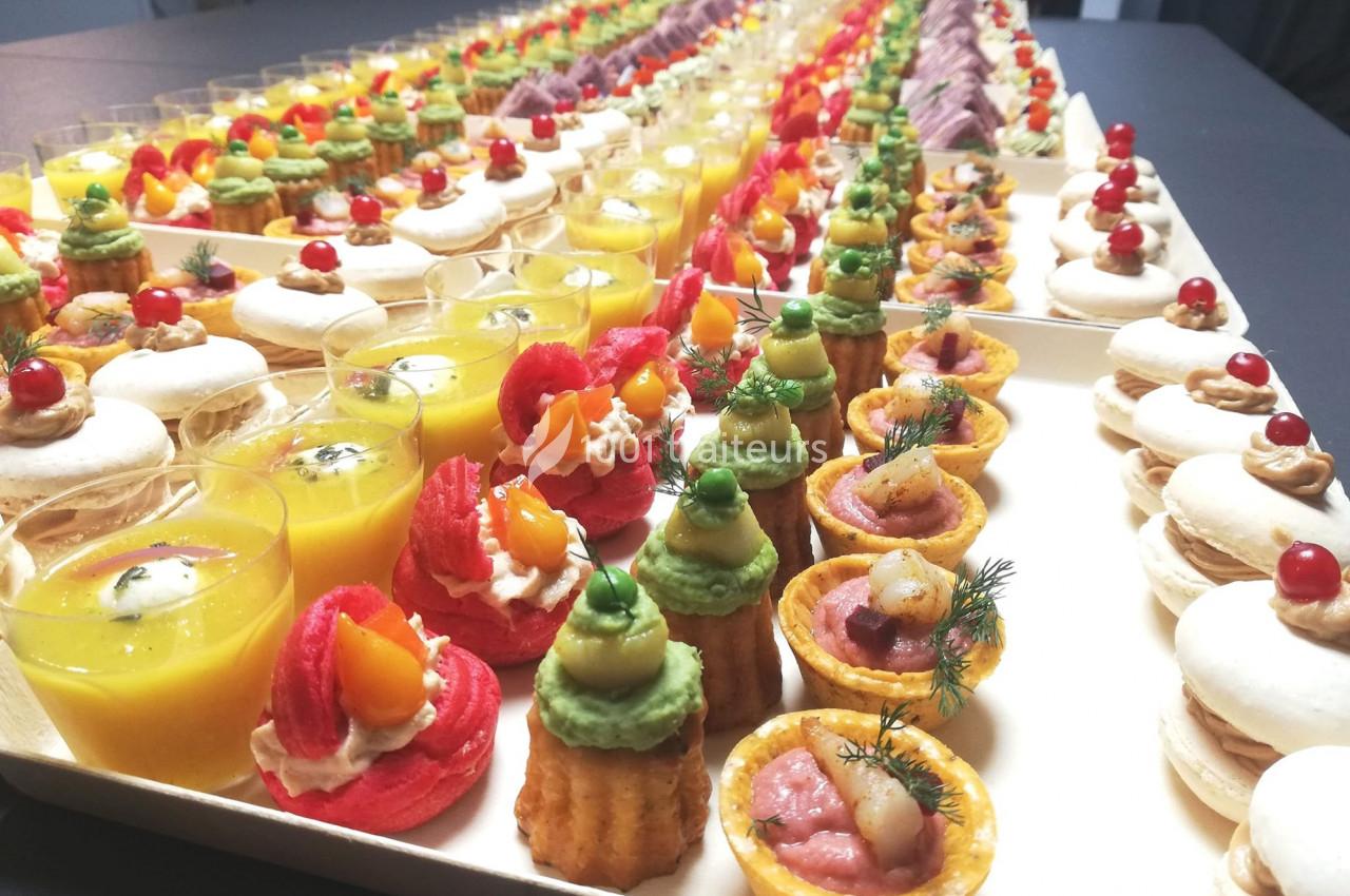 Plateau de bouchées apéritives variées comprenant verrines, macarons salés et mini-tartelettes colorées.