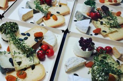 Tables dressées avec nappes beiges, décorées de bouquets de fleurs et d'ustensiles en bois, devant des volets bleus.