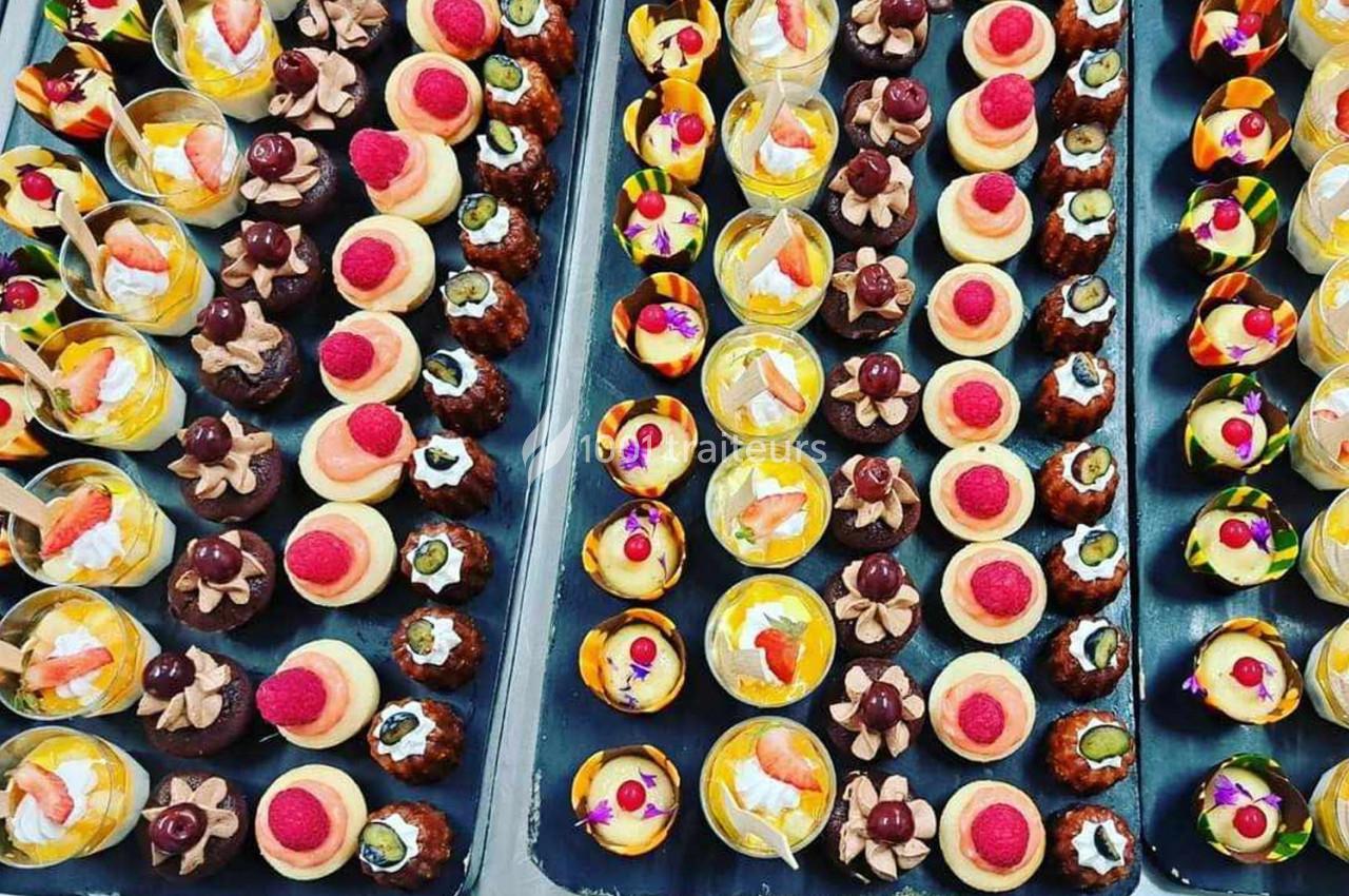 Plateaux garnis de divers desserts miniatures colorés, incluant des fruits, crèmes et décorations gourmandes.