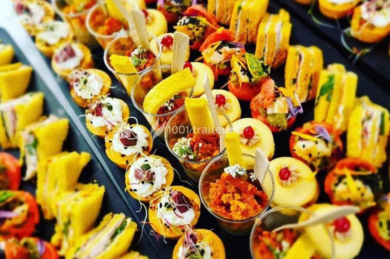 Plateau de bouchées variées comprenant verrines, mini-sandwichs, et amuse-bouches colorés.