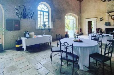 Tables dressées avec nappes beiges, décorées de bouquets de fleurs et d'ustensiles en bois, devant des volets bleus.