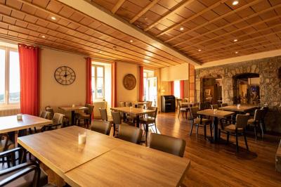 Cour pavée entourée de murs en pierre, avec des plantes en pot et une porte voûtée blanche.