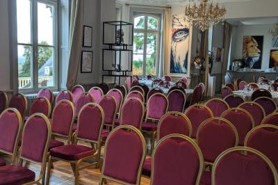 Deux chaises de bureau autour d'une table blanche dans une pièce lumineuse avec parquet et vue sur un jardin.