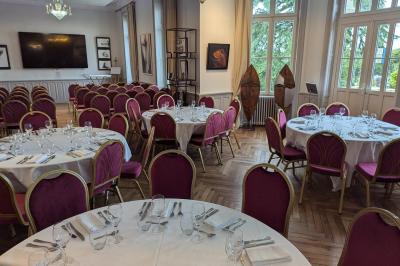 Deux chaises de bureau autour d'une table blanche dans une pièce lumineuse avec parquet et vue sur un jardin.
