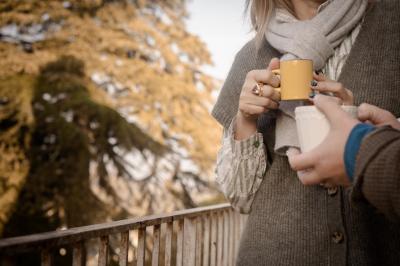 Deux chaises de bureau autour d'une table blanche dans une pièce lumineuse avec parquet et vue sur un jardin.