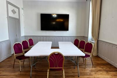 Deux chaises de bureau autour d'une table blanche dans une pièce lumineuse avec parquet et vue sur un jardin.