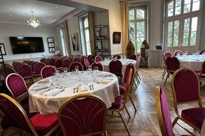 Deux chaises de bureau autour d'une table blanche dans une pièce lumineuse avec parquet et vue sur un jardin.