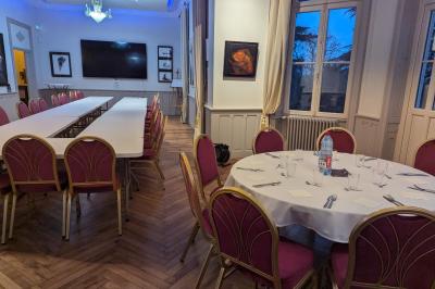 Deux chaises de bureau autour d'une table blanche dans une pièce lumineuse avec parquet et vue sur un jardin.