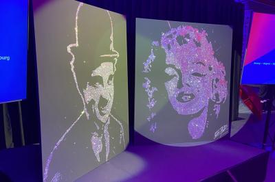 Deux tableaux scintillants représentant Charlie Chaplin et Marilyn Monroe sur une scène sombre.