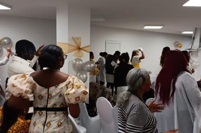 Rangées de chaises rouges alignées dans une salle vide avec un sol en béton et des murs blancs.