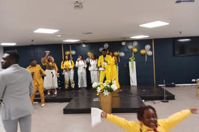 Rangées de chaises rouges alignées dans une salle vide avec un sol en béton et des murs blancs.