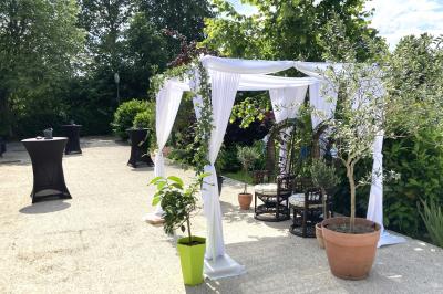 Homme concentré cuisinant en extérieur sur une plancha, entouré de végétation sous un ciel nuageux.