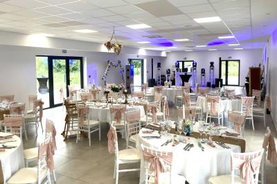 Homme concentré cuisinant en extérieur sur une plancha, entouré de végétation sous un ciel nuageux.