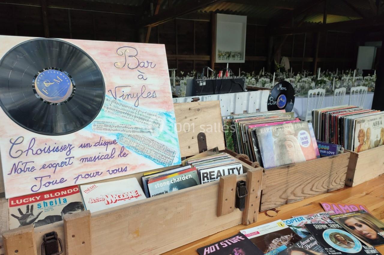 Disques vinyles exposés dans des caisses en bois, avec une pancarte indiquant ’Bar à Vinyles’ dans un cadre rustique.