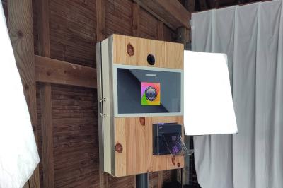 Un DJ mixe dans une salle éclairée par des lumières colorées, avec des tables hautes et un décor sobre.