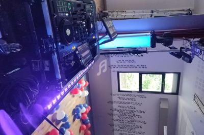 Équipement de DJ avec platines et éclairage violet, installé dans une salle décorée de ballons rouges, blancs et bleus.