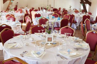 Centre de table en métal doré avec un bouquet de roses blanches et roses, sur une table de réception décorée.