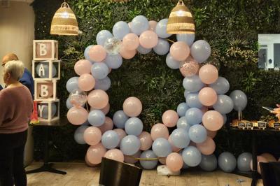 Terrasse d'un café avec des tables et des chaises colorées devant une façade vitrée portant l'inscription ’Au Bout du Bar’.