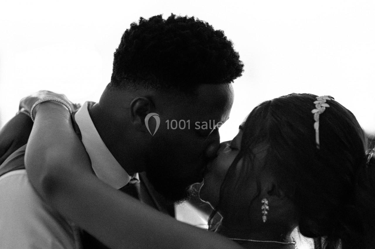 Un couple s'embrasse tendrement lors d'un moment intime, capturé en noir et blanc.