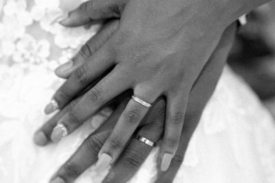 Un couple échange ses vœux de mariage dans une salle ornée de fresques et d'un lustre imposant.