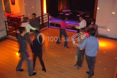 Miniature Location salle Nanterre (Hauts-de-Seine) - Le Cinéart #14 Table décorée pour un mariage avec chaises blanches, nappe bleue, fleurs blanches et éléments dorés sur une estrade.