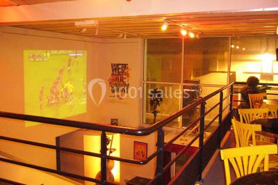 Miniature Location salle Nanterre (Hauts-de-Seine) - Le Cinéart #17 Table décorée pour un mariage avec chaises blanches, nappe bleue, fleurs blanches et éléments dorés sur une estrade.