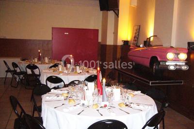 Miniature Location salle Nanterre (Hauts-de-Seine) - Le Cinéart #11 Table décorée pour un mariage avec chaises blanches, nappe bleue, fleurs blanches et éléments dorés sur une estrade.