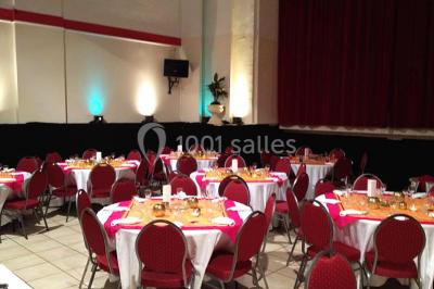 Miniature Location salle Nanterre (Hauts-de-Seine) - Le Cinéart #5 Table décorée pour un mariage avec chaises blanches, nappe bleue, fleurs blanches et éléments dorés sur une estrade.
